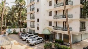 an apartment building with cars parked in a parking lot at Staymaster Veridian Standard 2BHK Near Calangute Beach in Calangute
