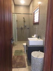 ein Badezimmer mit Waschbecken, Toilette und Dusche in der Unterkunft The Weekender in Kunkunu
