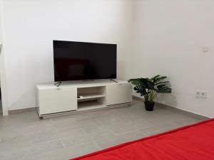 a white entertainment center with a flat screen tv on a wall at Rentdragoana in Costa Del Silencio