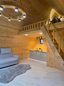 a living room with a staircase in a wooden house at Кольсай Тау Оректы resort in Kurmenty