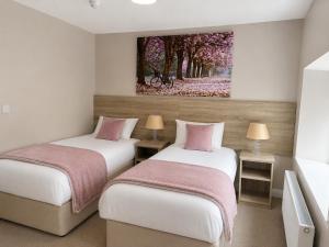 two beds in a room with a painting on the wall at Grove house Dunleer in Dún Léire