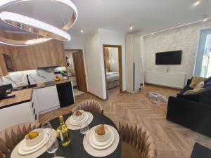 a kitchen and a living room with a dining table at Prime Luxury Apartman in Mátészalka