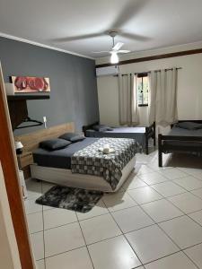 a bedroom with two beds and a living room at Prime Garden Pousada in Socorro