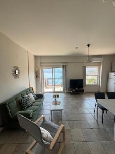 a living room with a green couch and a table at Stergios Apartment Evdilos Ikaria in Evdilos
