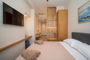 a bedroom with a bed with a television on the wall at Perla Port Suites in Chios