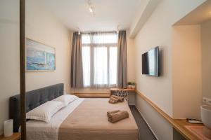 a small room with a bed and a television at Perla Port Suites in Chios