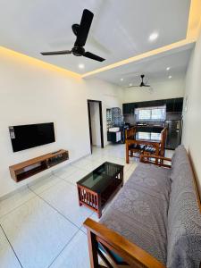 a living room with a couch and a flat screen tv at JK Homes in Alwaye