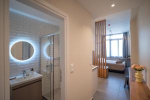 a bathroom with a shower and a sink and a mirror at Perla Port Suites in Chios +47 photos