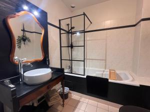 a bathroom with a sink and a tub at La Maison du Cèdre in Bénévent-lʼAbbaye +56 photos