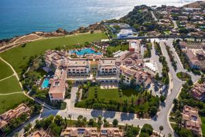 an aerial view of a large house on a hill next to the ocean at Cascade Wellness Resort Lagos Algarve by Domes in Lagos