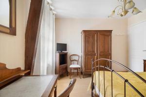 a bedroom with a bed and a table and a chair at L'aoûtienne - 300m de la plage in Saint-Coulomb
