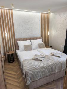 a bedroom with a large bed with white sheets at Prime Luxury Apartman in Mátészalka