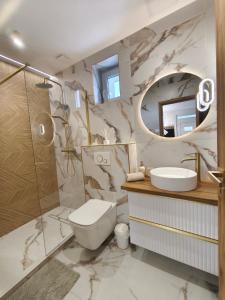 a bathroom with a sink toilet and a mirror at Prime Luxury Apartman in Mátészalka +16 photos