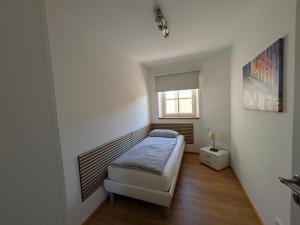 a small bedroom with a bed and a window at Golfsuite Axel in Uttlau-Haarbach in Haarbach