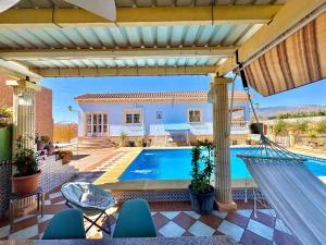 a house with a swimming pool and a patio at Villa Mansa in Pechina