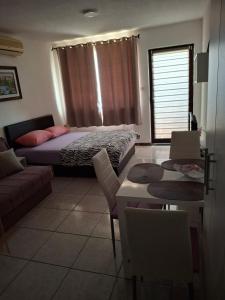 a bedroom with a bed and a couch and a table at Apartments Petrovic in Krimovice