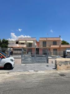 a white car parked in front of a gate at Villa Olimpia in Civitavecchia