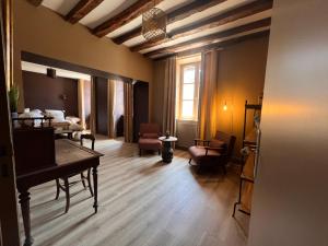 a living room with a piano and a room with chairs at La Maison du Cèdre in Bénévent-lʼAbbaye