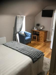 a bedroom with a bed and a chair and a desk at The Bridge in Ballyconnell +18 photos
