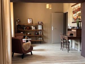 a living room with a table and a chair at La Maison du Cèdre in Bénévent-lʼAbbaye