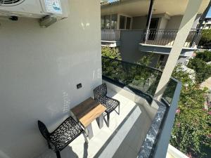 a balcony with two chairs and a wooden table at Benan Apart Otel Didim in Didim