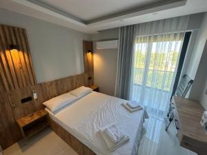 a bedroom with a bed and a large window at Benan Apart Otel Didim in Didim
