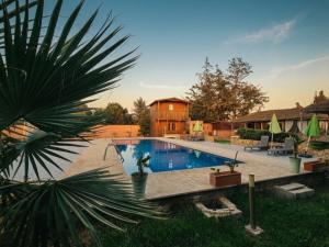 a large swimming pool with a house in the background at Ferme Sacrée Nature in Ben Slimane