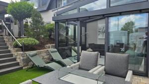 a patio with two chairs and a table and glass at Auszeit Eifel Ihre private Auszeit zu zweit in Reuth