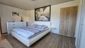 a bedroom with a bed and a dresser and a door at Auszeit Eifel Ihre private Auszeit zu zweit in Reuth