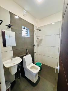 a bathroom with a toilet and a sink and a shower at JK Homes in Alwaye +34 photos