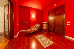 a red room with a chair and a door at Villa G in Ravenna