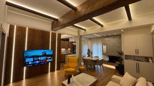ein Wohnzimmer mit Sofa und ein Esszimmer in der Unterkunft Chōros in Larisa