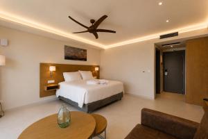 a bedroom with a bed and a ceiling fan at LEOLIA Nautical Resort Kala Nera - Handwritten Collection in Volos +31 photos