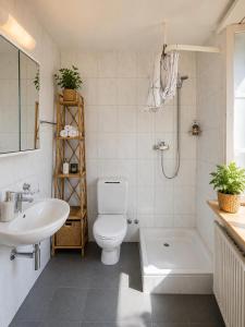 a bathroom with a toilet and a sink and a shower at KB CityRooms Self-Check-In in Lucerne +52 photos