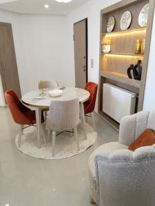 a dining room with a white table and chairs at Résidence Costa in Sousse