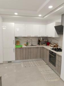 a kitchen with white cabinets and a sink at Résidence Costa in Sousse +2 photos