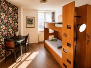 a small room with a bunk bed and a table at KB CityRooms Self-Check-In in Lucerne