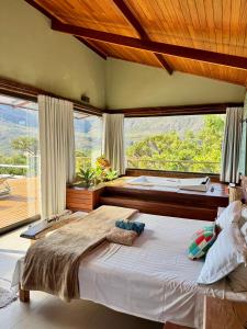 a bedroom with a large bed with a large window at Casa do Teuler - Lapinha da Serra in Santana do Riacho +105 photos
