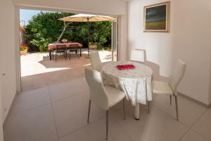 a dining room with a table and chairs and an umbrella at House Nada 1201 in Banjole