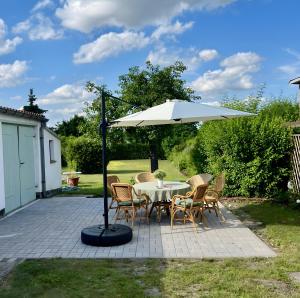 a table and chairs under an umbrella on a patio at Dahlienhof in Wittenberge