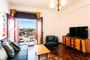 uma sala de estar com um sofá e uma televisão em WHome | Damasceno Large Apartment #39 em Lisboa