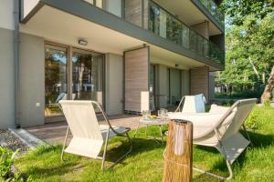 a patio with chairs and a table in front of a house at Wydmove Łeba Q4 Apartments in Łeba