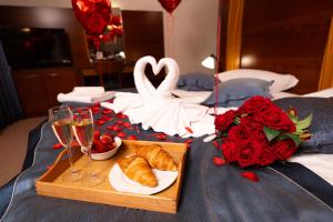 a tray of croissants and champagne glasses on a bed at Etno selo Stanišići Hotel Ras in Dijelovi