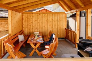a wooden patio with a table and chairs at Villa Rustica in Bešeňová
