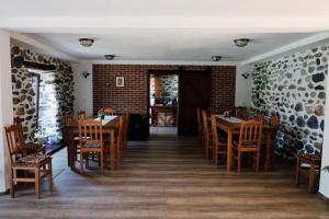 a dining room with wooden tables and chairs at Casa de Piatra in Porumbacu de Sus