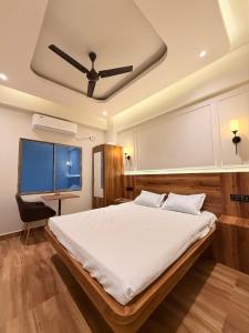 a bedroom with a large bed with a ceiling at Rishaan Regency in Silchar