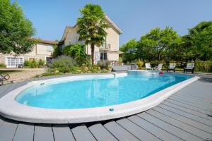 a swimming pool on a wooden deck next to a house at Gite L'Aventura in Régades