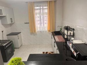 a kitchen with black counter tops and a window at Nalim bliss garden in Ruiru