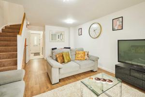 a living room with a couch and a television at Host & Stay - Fells Paddock in Bedford +20 photos