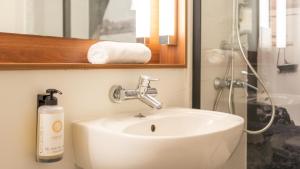 a bathroom with a white sink and a mirror at Campanile NATURE - Vannes in Vannes +18 photos
